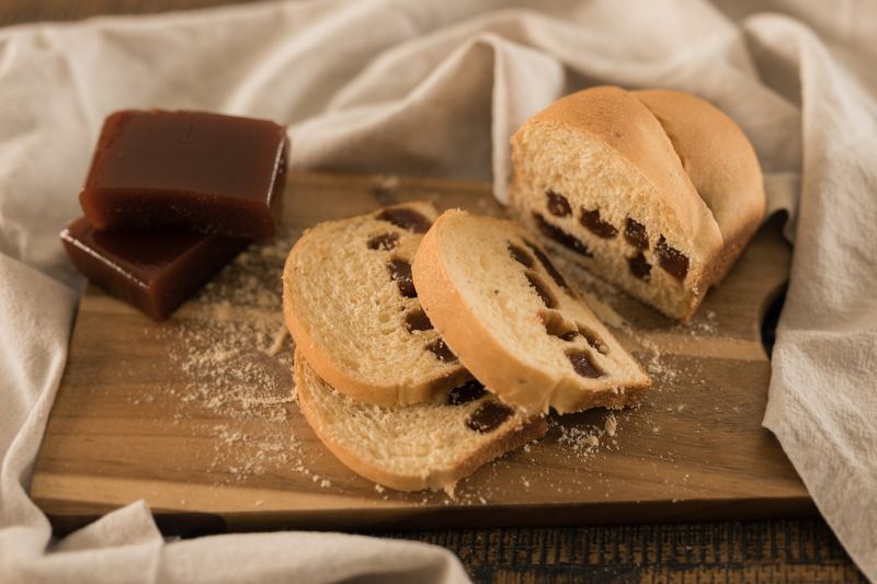 Pão de fubá com goiabada fatiado sobre tábua