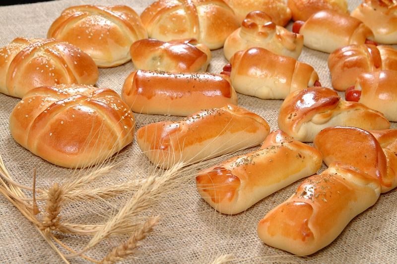 Salgados assados dourados: esfihas, enrolados e calzones